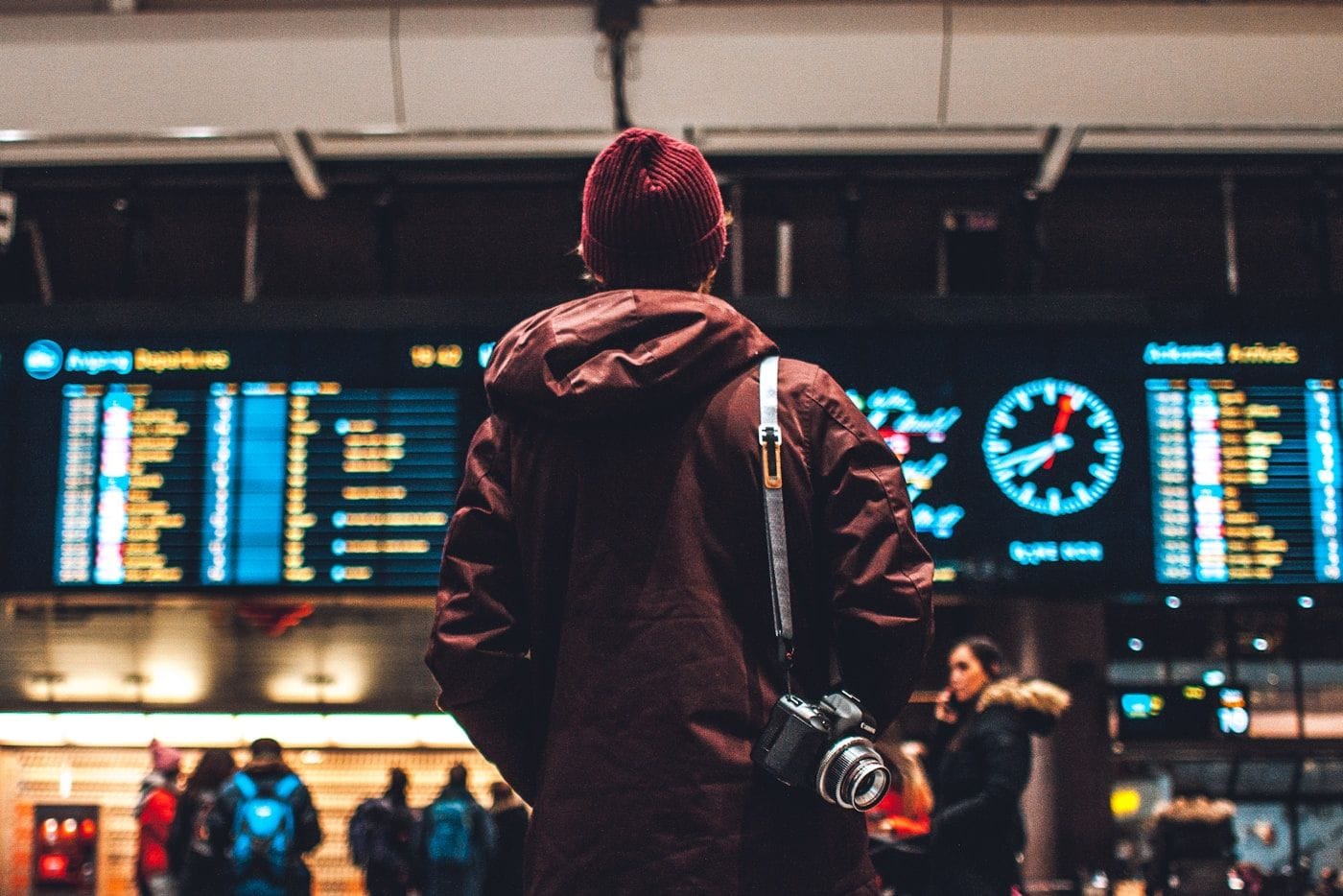 A traveller walking through a bright modern airport concourse